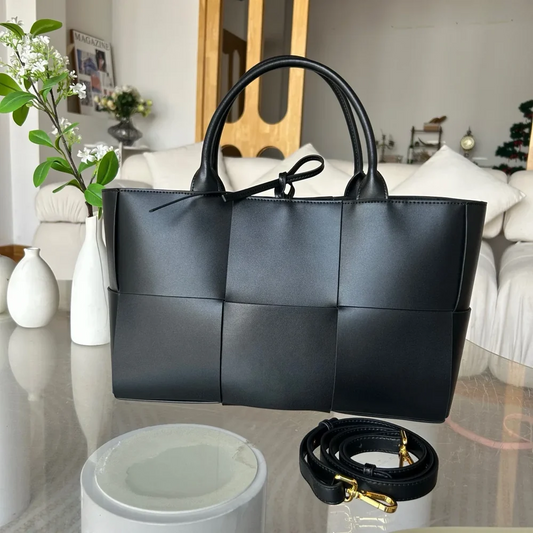 Black genuine leather woven tote bag with top handles and detachable shoulder strap