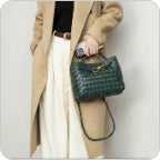 Dark olive green knotted intrecciato lambskin leather shoulder bag worn on shoulder